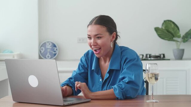 Excited young woman winner looks at laptop and clap one's hands. Euphoric lady gets new distance job opportunity, reads good news in email, rejoices victory, feels motivated.