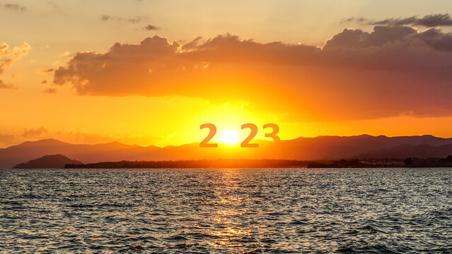 Happy New Year 2023 anniversary. Transition from 2022 to new year 2023 concept with text on sun rising sky. Photo image can be used as large display, print, website banner, social media post