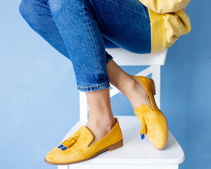 Stylish yellow suede loafers on the girl's feet. Fashionable and stylish shoes and beautiful shoes.