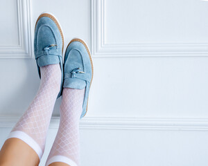 Stylish suede light blue loafers at the girl's feet. Fashionable and stylish shoes and beautiful...