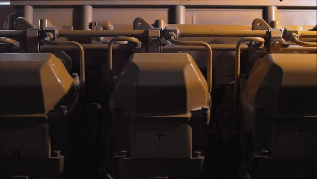 Cylinders of a huge diesel engine of a seagoing vessel in dynamic light. Close-up 