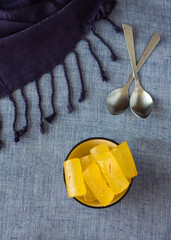 Top view of Indian sweet commonly known as Kesar Angoori Petha or Petha. Bowls placed on blue...