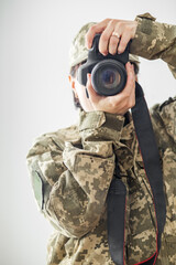 Military press photographer woman with professional camera on white background