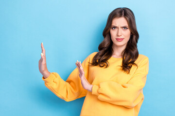 Photo portrait of pretty young woman stretch hands keep distance reject gesture wear trendy yellow look isolated on blue color background