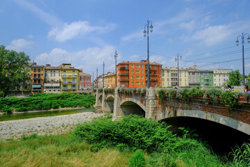 Parma, Italy: bridge Ponte del Mezzo over the river Torrente di Parma across the colorful buildings on a sunny day