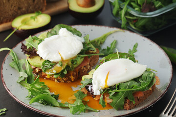 Homemade sandwiches with salmon, avocado and poached eggs