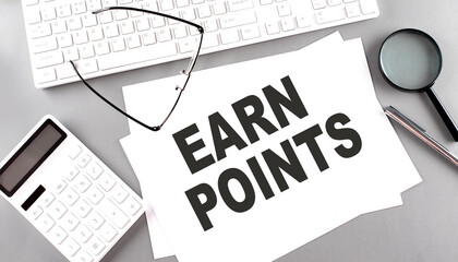 EARN POINTS text on paper with keyboard, calculator on grey background