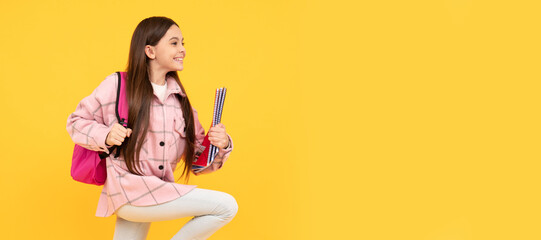 happy teen girl wear pink checkered shirt running with school bag and notebooks, runner. Banner of school girl student. Schoolgirl pupil portrait with copy space.