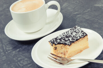 Fresh baked cheesecake and cup of coffee with milk. Delicious dessert