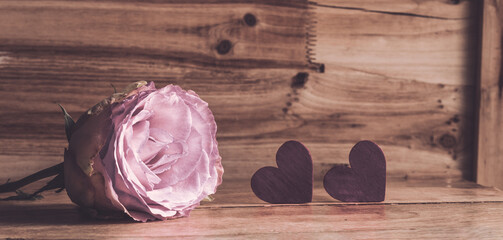Rose in pink und zwei Herzen vor Holz zum Beschreiben Panorama