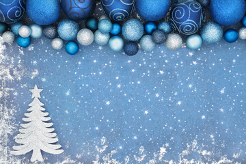 Christmas tree abstract background border on blue grunge with glitter bauble decorations. Xmas...