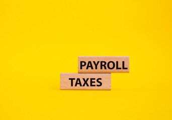 Payroll taxes symbol. Concept word Payroll taxes on wooden blocks. Beautiful yellow background. Business and Payroll taxes concept. Copy space