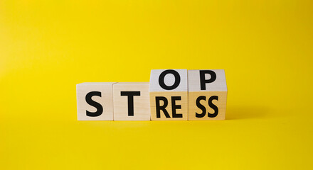 Stop and Stress symbol. Turned wooden cubes with words Stress and Stop. Beautiful yellow background. Business and Stop Stress concept. Copy space.