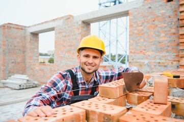 Construction worker man in work clothes and a construction helmet. Portrait of positive male...