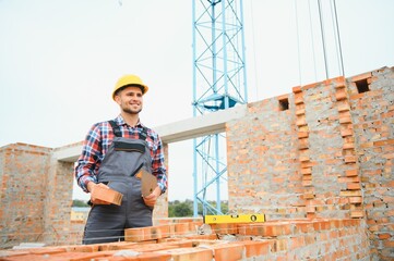 Construction worker man in work clothes and a construction helmet. Portrait of positive male...
