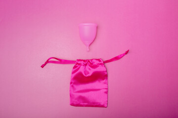 menstrual cup and storage bag on pink background