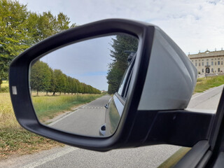 Fototapeta na wymiar Specchietto retrovisore dell'automobile - guidare in campagna