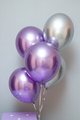 chrome latex balloons in purple and silver color on the background of the wall