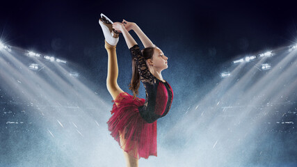 Little girl, figure skater wearing beautiful dress performing short program over ice arena background. Dance, winter sports, achievements, champion concept © master1305