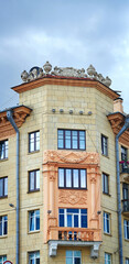Fototapeta na wymiar Balcony with columns on facade of old residential building decorated with bas-reliefs. Stalinist architecture, Stalin Empire style. Balcony and windows of soviet building.