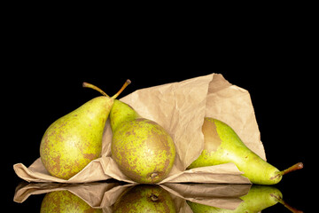 Fototapeta na wymiar Three juicy organic pears in a paper bag, close-up, isolated on a black background.