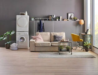 Washing and drier machine in the grey wall room background, laundry, clothe, sofa and working table style, minimalist home interior.