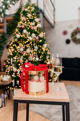 Festive Christmas cake in a package with a red bow and champagne glasses