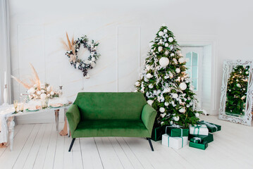 White Christmas room with a Christmas tree decorated with white and green toys.