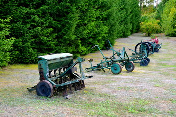 A close up on an old ploughing machine used by peasants and farmers many years ago with proper handles, curved frame and metal elements seen on a well maintained lawn in Poland in summer