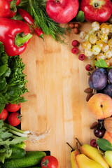 Vegetables and fruits around a wooden board. Healthy food concept. Bright background with space for writing text.
