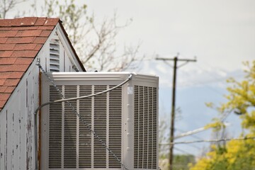 An air conditioning unit near a roof peak