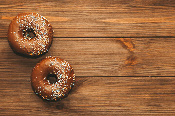 Round-shaped donuts with chocolate glaze and colored sprinkles.