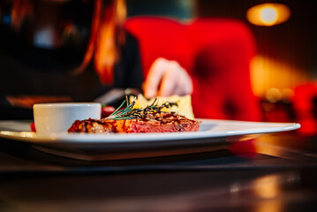 woman hands with fork and knife eating food in cafe
