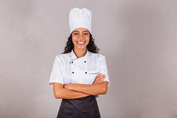 young black brazilian woman, cook, masterchef. With arms crossed. smiling.