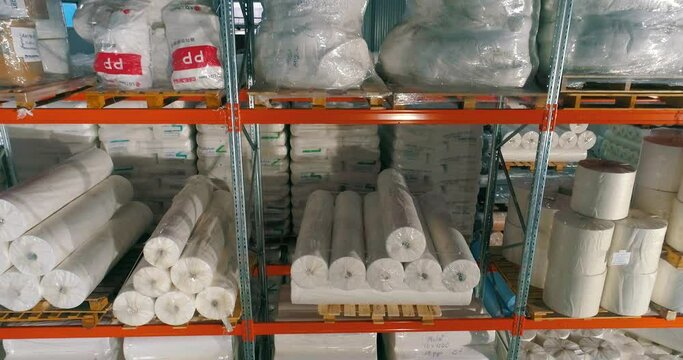 Warehouse at the nonwovens factory. Flight to the warehouse of non-woven fabrics. Large modern warehouse with synthetic winterizer rolls