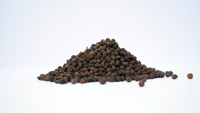 Pile of Organic Black pepper (Piper nigrum) isolated on white background. milled black pepper ,Black pepper corns. Black pepper grains as background close up