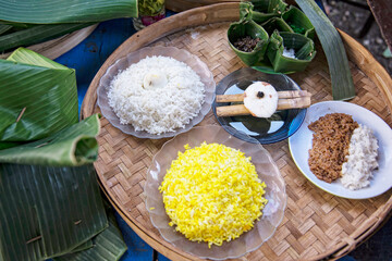 Obraz na płótnie Canvas Ryż biały, żółty i brązowy na talerzu uplecionym z liści, azjatycka kuchnia, zdrowa dieta