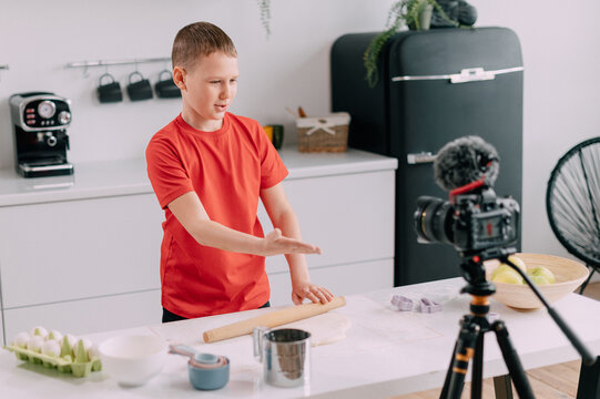 A child blogger makes a tutorial video at home. The boy shows how to make dough.
