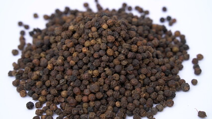 Pile of Organic Black pepper (Piper nigrum) isolated on white background. milled black pepper ,Black pepper corns. Black pepper grains as background close up