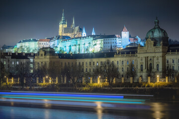 Hradcany, St Vitus Cathedral and Vltava river at night with blurred boat, Prague