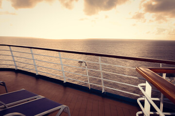 Wooden deck and railing from cruise ship. Beautiful sunset and ocean view.