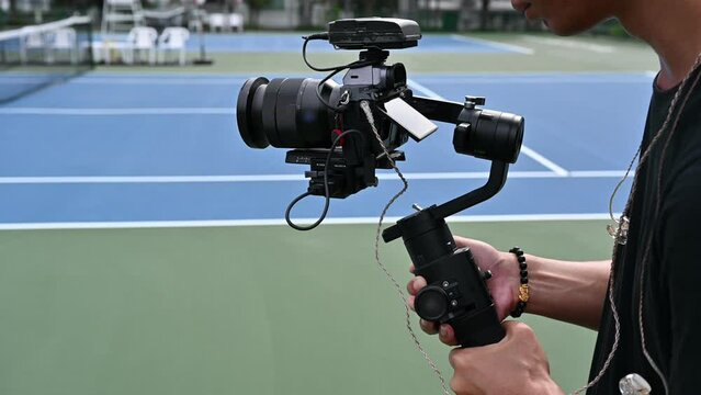 Videographer recording with mirrorless camera with mic wireless on gimbal stabilizer