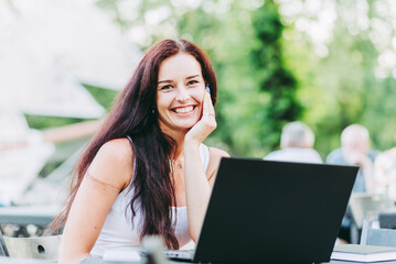 Young sensuality caucasian business woman with brunette hair working on laptop in outdoor cafe....