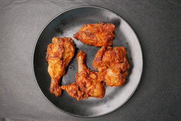  fried chicken fillets on plate on black background 