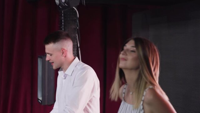 Musicians Duet performans on stage with piano and background interactive board