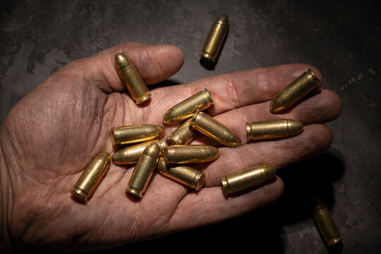 9mm pistol cartridges in the palm of a man.