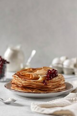 Thin pancakes in milk with berries on a white background