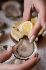 Squeezing lemon on oyster