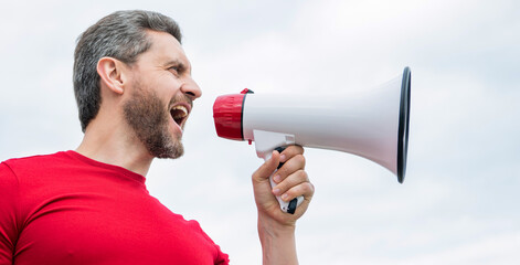 man in red shirt shout in loudspeaker on sky background. propaganda