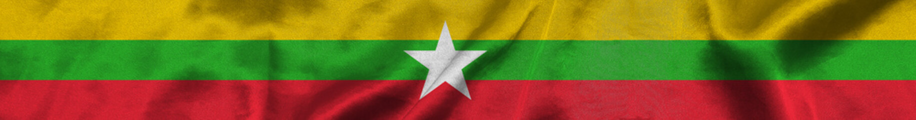 Elongated national flag of Myanmar with a fabric texture fluttering in the wind. Myanmar flag for website design. 3d illustration